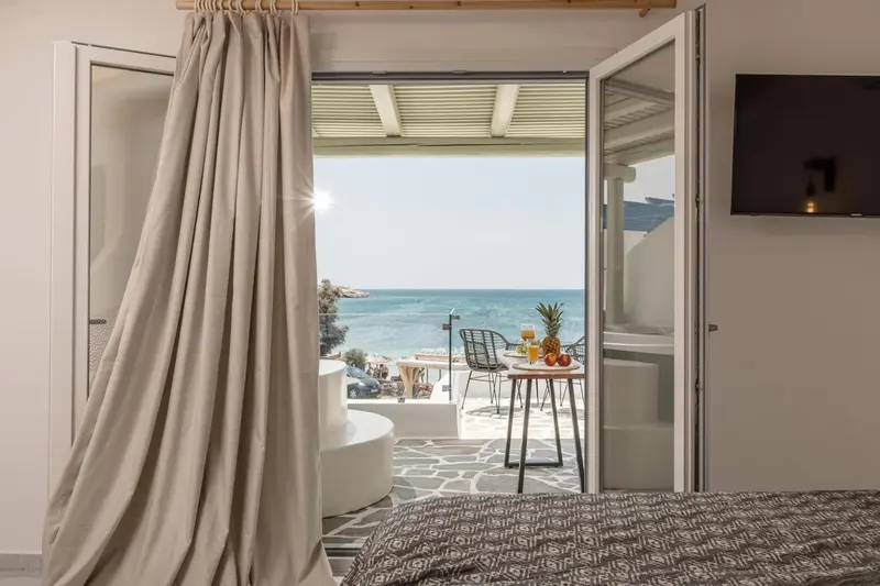 Une chambre s'ouvre sur une terrasse avec vue sur la mer.