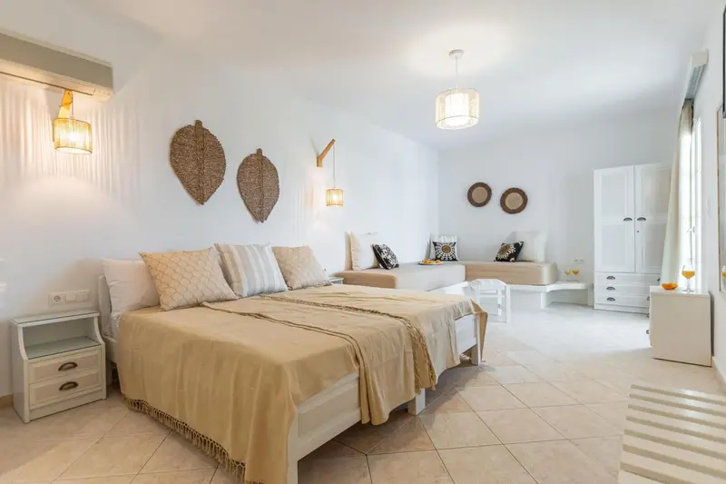 Une chambre lumineuse avec un grand lit et un canapé.