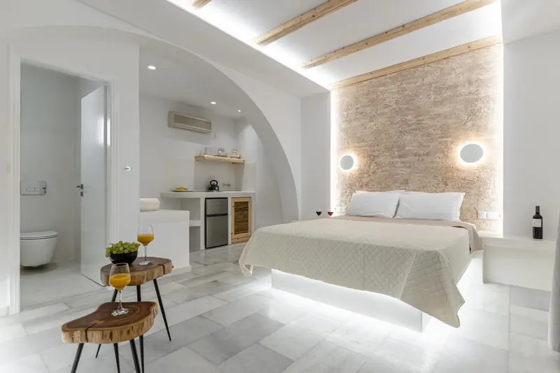 Une chambre lumineuse avec un lit et un coin cuisine.