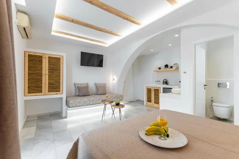 Une chambre lumineuse avec un lit et un coin salon.
