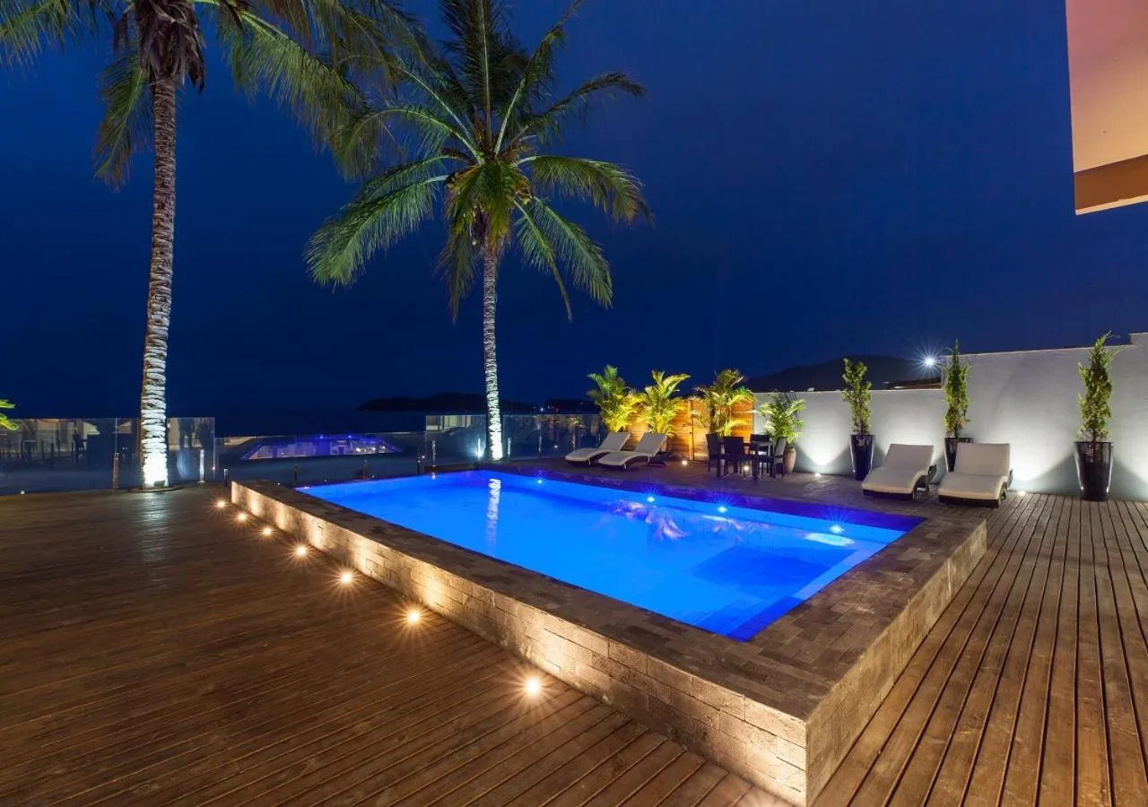 Piscine illuminée au crépuscule avec mobilier de détente.