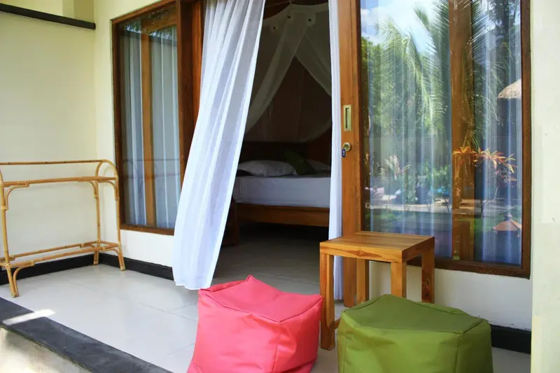 Une terrasse mène à une chambre avec un lit à baldaquin.