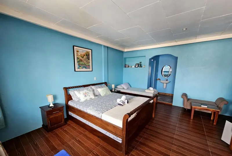 Une chambre lumineuse avec un grand lit et un mobilier en bois.