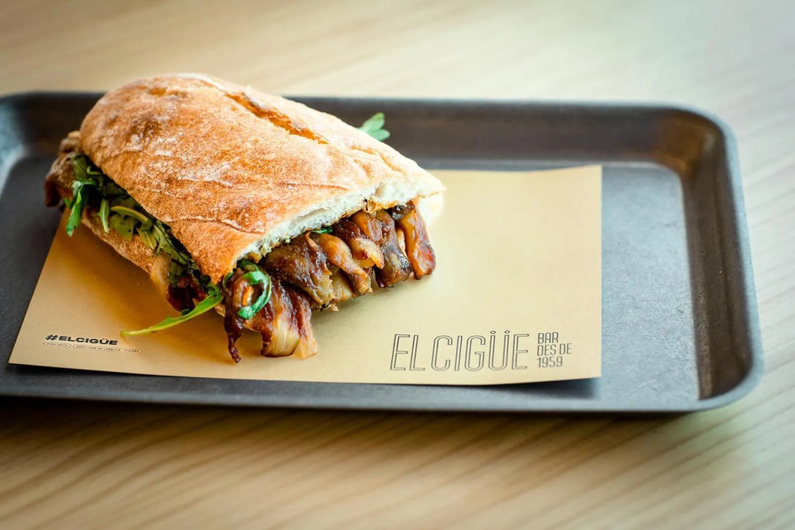 Un sandwich garni est présenté sur une plaque en métal.