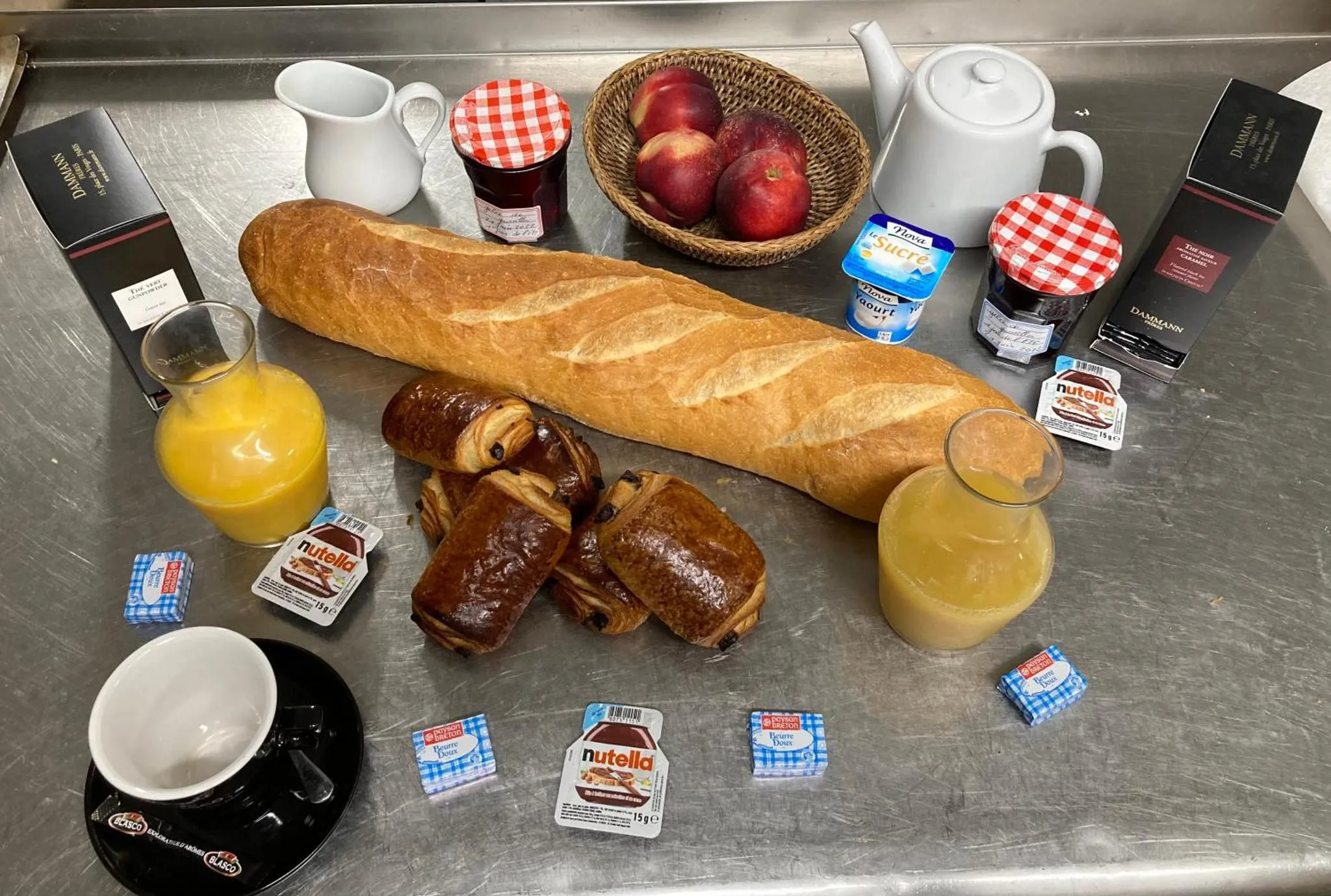 Un plateau de petit-déjeuner avec viennoiseries, fruits et boissons.