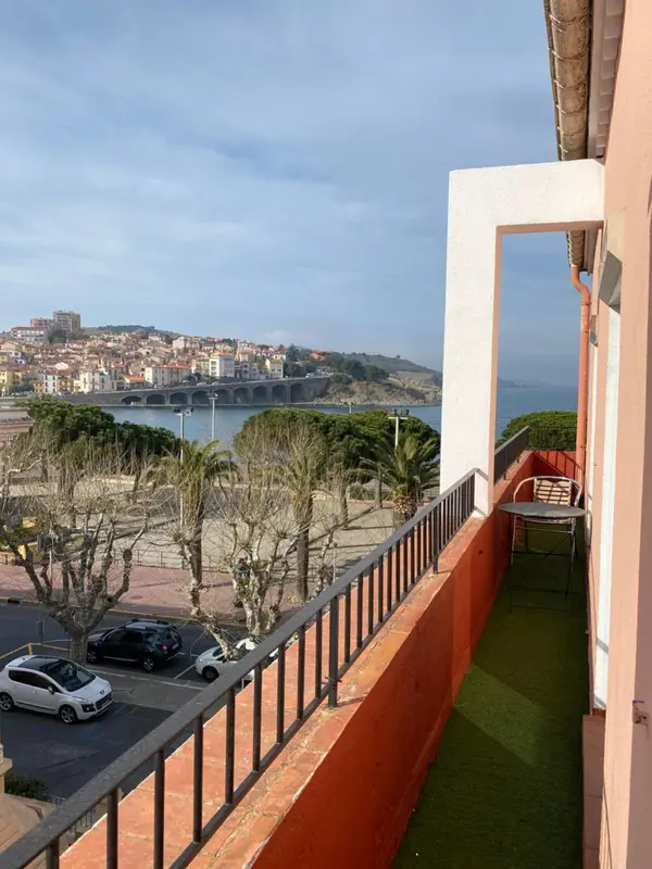 Vue d'un balcon donnant sur une ville côtière et la mer.