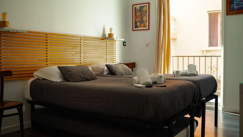 Une chambre avec un lit double et un accès à un balcon.