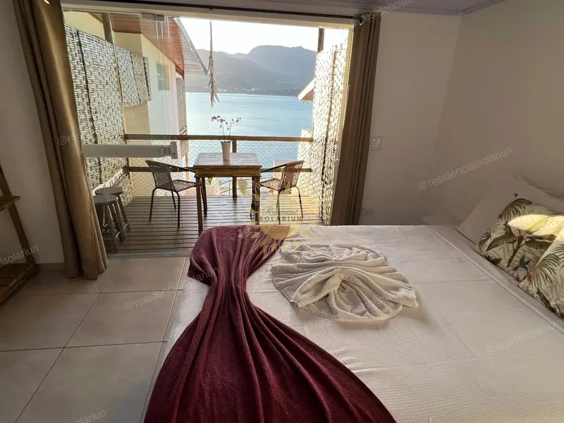 Une chambre lumineuse s'ouvre sur une terrasse avec vue sur la mer.
