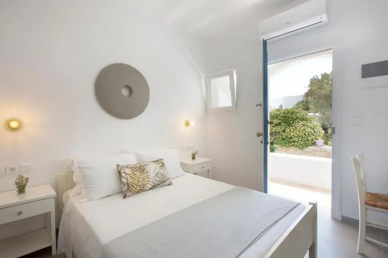 Une chambre lumineuse avec un lit simple donnant sur une terrasse.