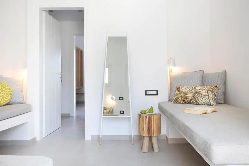 Intérieur clair avec un lit et un miroir mural.