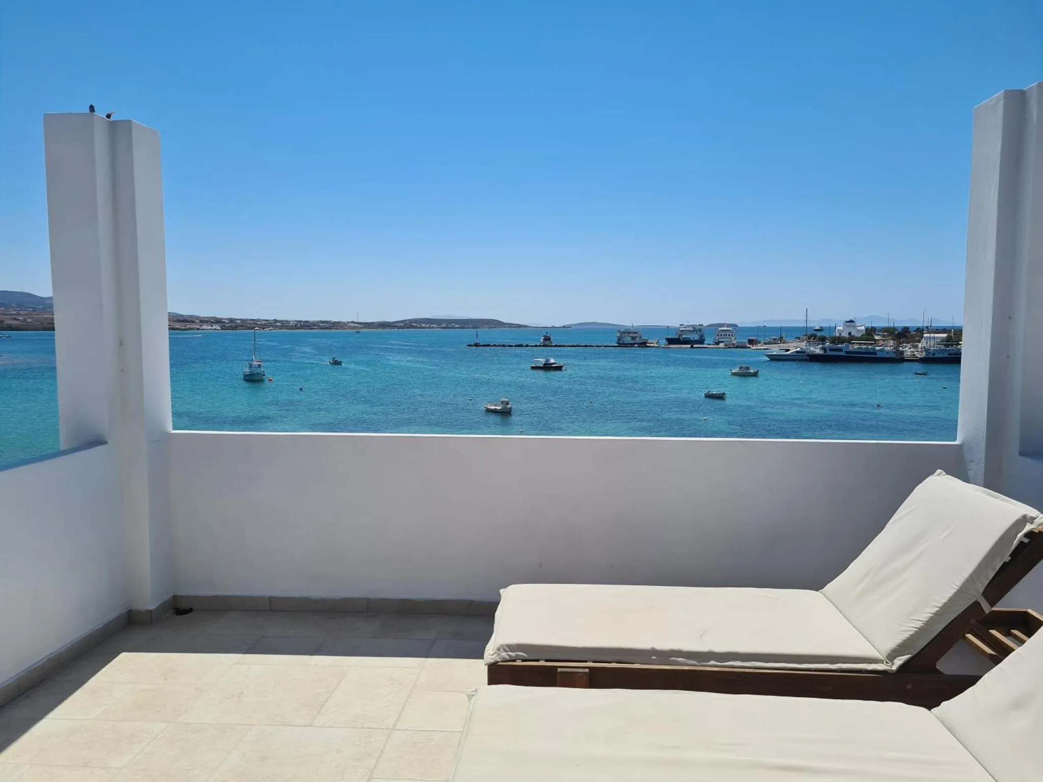 Vue sur la mer depuis une terrasse avec des transats.