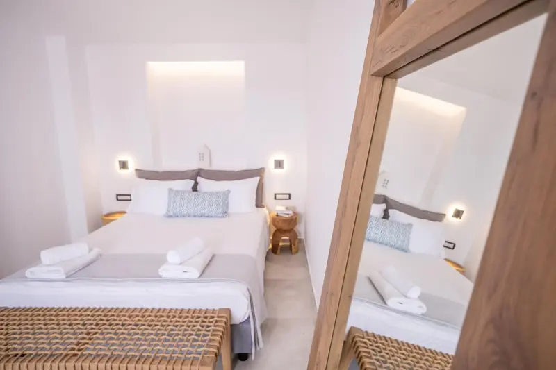 Une chambre lumineuse avec un grand lit et un miroir.