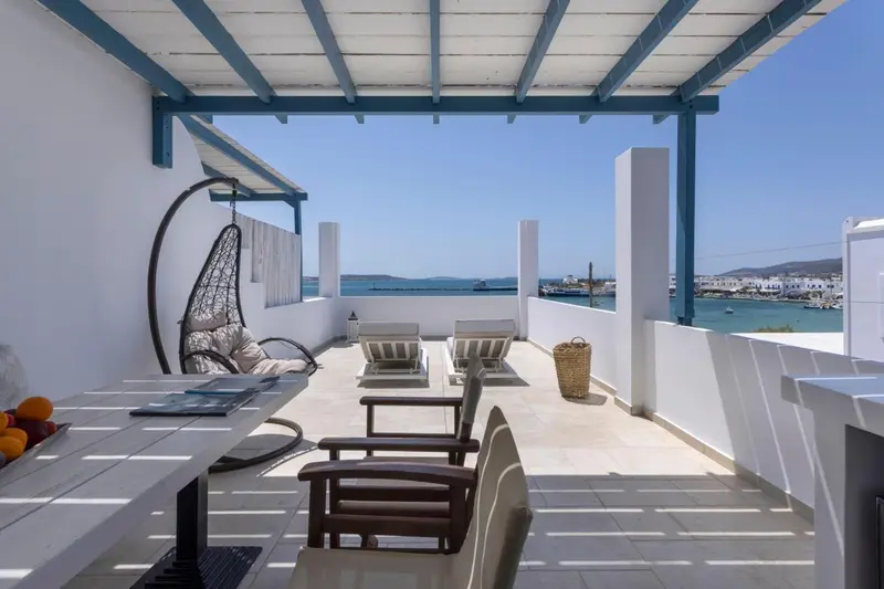Terrasse aménagée avec mobilier de jardin et vue sur la mer.