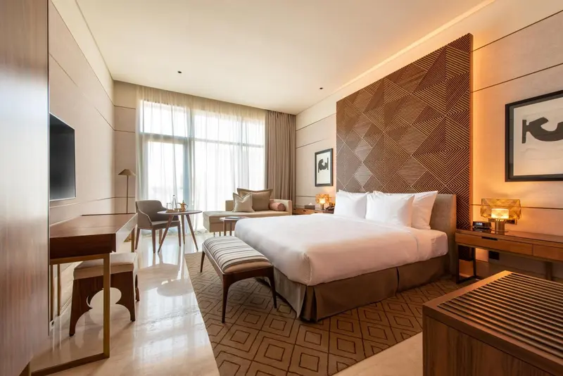 Une chambre d'hotel moderne avec un grand lit et un espace salon.