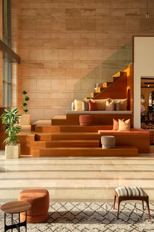 Espace de détente intérieur avec des assises en bois et des coussins.