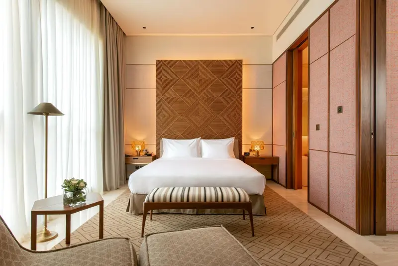 Une chambre lumineuse avec un grand lit et une décoration moderne.