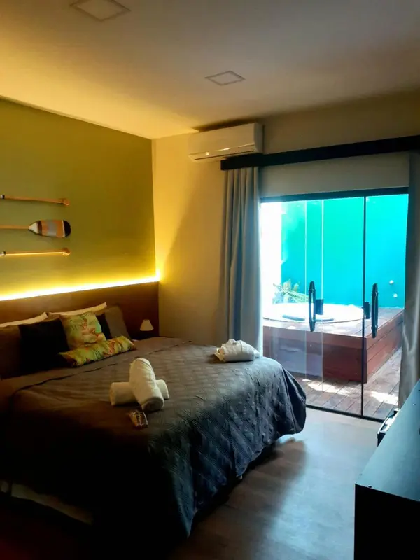 Une chambre avec un grand lit et une vue sur l'eau à travers une baie vitrée.