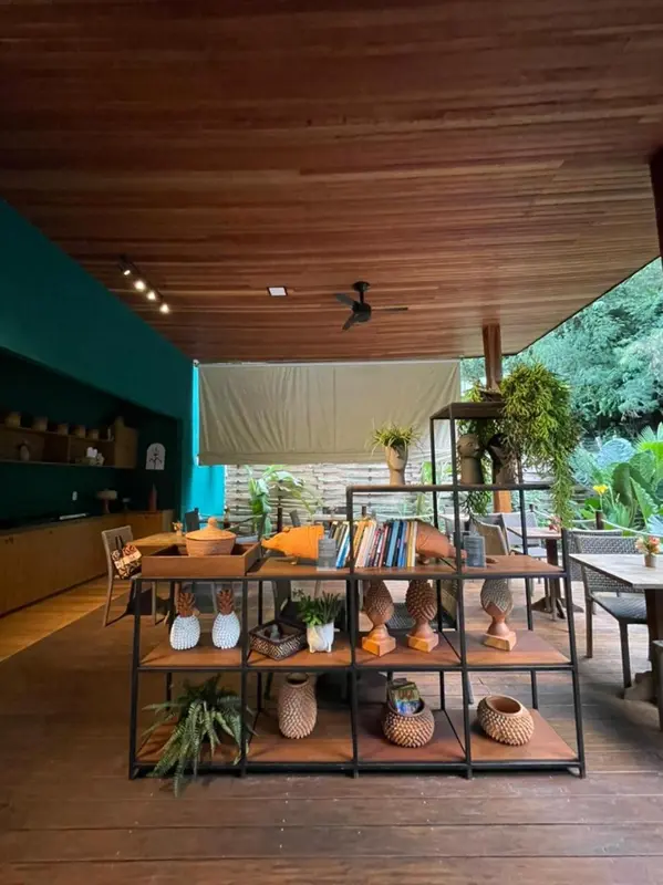 Espace extérieur couvert avec mobilier en bois et étagères décoratives.