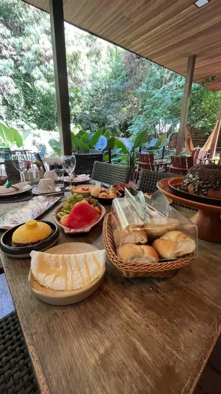 Une table en bois est dressée avec des plats variés et des couverts.