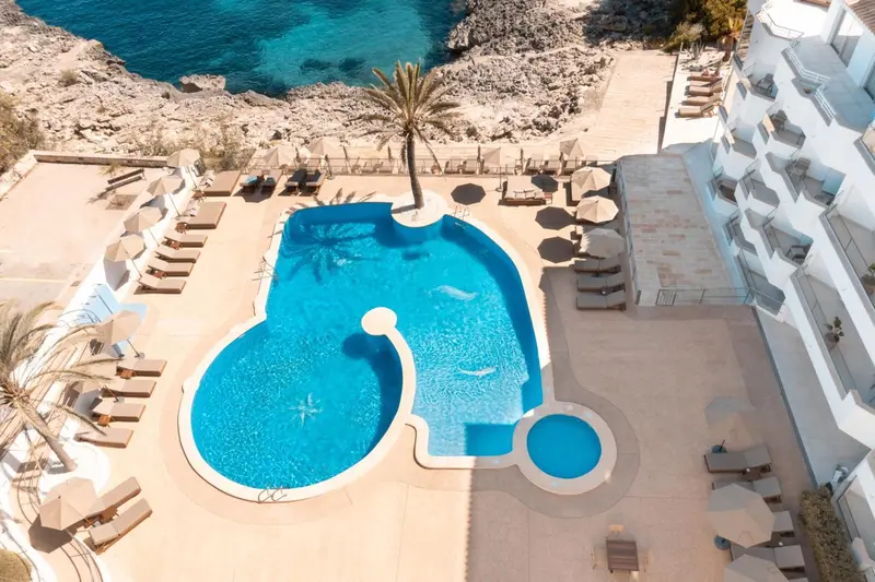 Vue aérienne d'une piscine en forme de cœur dans un complexe hôtelier.