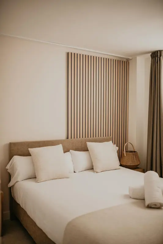 Un lit double avec oreillers blancs dans une chambre lumineuse.