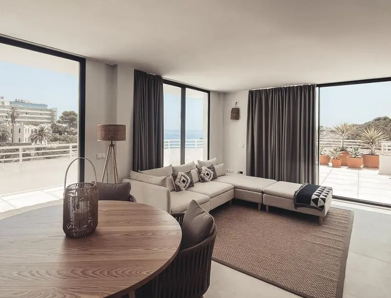 Un salon lumineux s'ouvre sur une terrasse avec vue sur la mer.