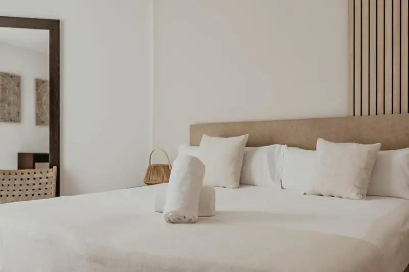 Un lit double est fait avec des oreillers blancs et des couvertures.