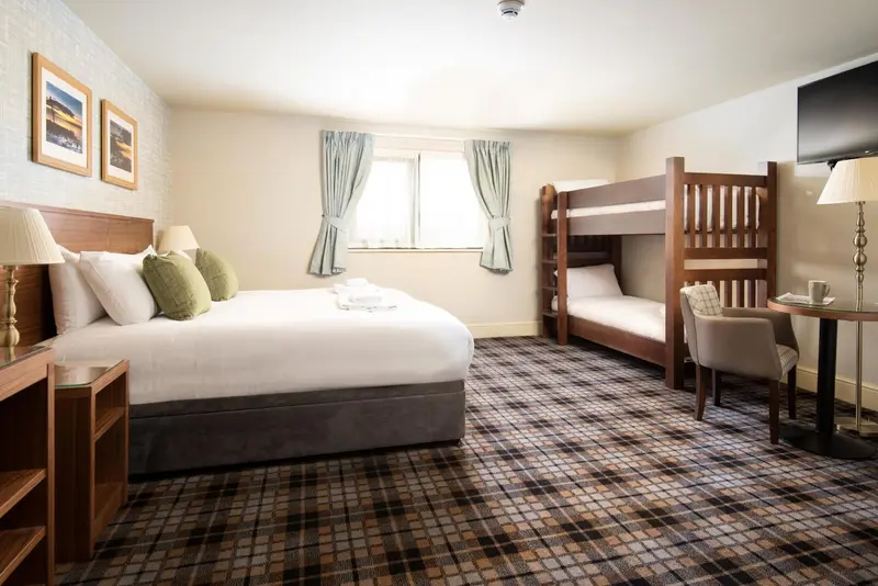 Une chambre d'hôtel avec un lit double et un lit superposé.