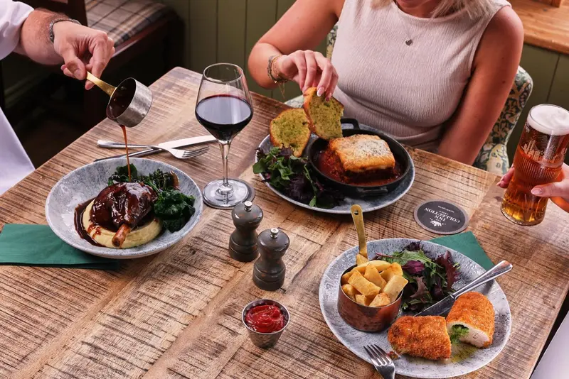 Une table est dressée avec des plats variés et des boissons.