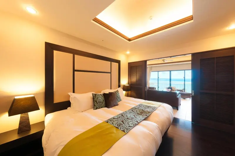 Une chambre lumineuse avec un grand lit et un accès à une terrasse.