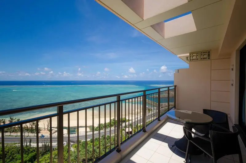 Vue sur la mer depuis un balcon avec mobilier d'extérieur.