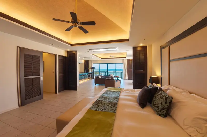 Une chambre spacieuse avec un grand lit et un accès à une vue sur l'océan.