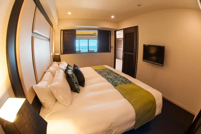 Une chambre lumineuse avec un grand lit et une vue sur la mer.