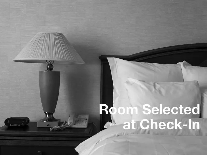 Une chambre d'hôtel avec un lit et une lampe de chevet.