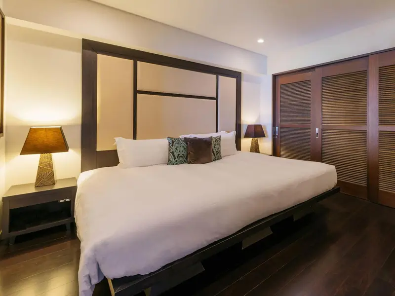 Une chambre lumineuse avec un grand lit et des tables de chevet.