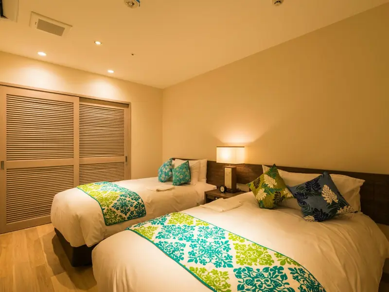 Une chambre lumineuse avec deux lits simples et une décoration florale.