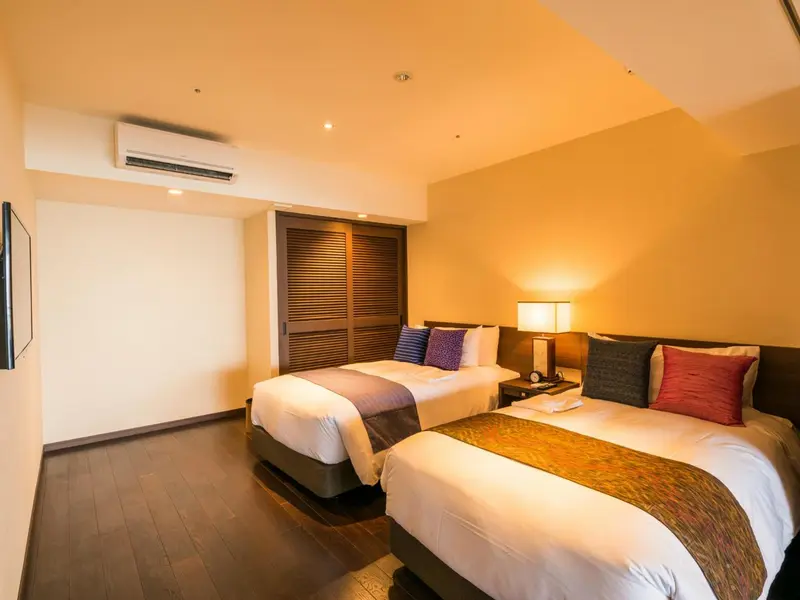 Une chambre d'hôtel avec deux lits simples et une décoration chaleureuse.