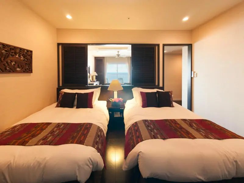 Une chambre avec deux lits simples et une décoration sobre.