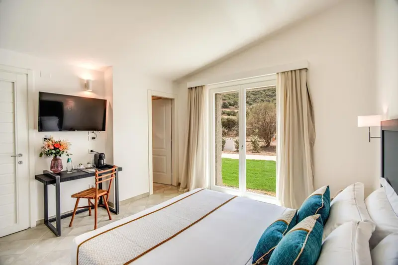 Une chambre lumineuse avec un lit fait et un bureau près d'une fenêtre.