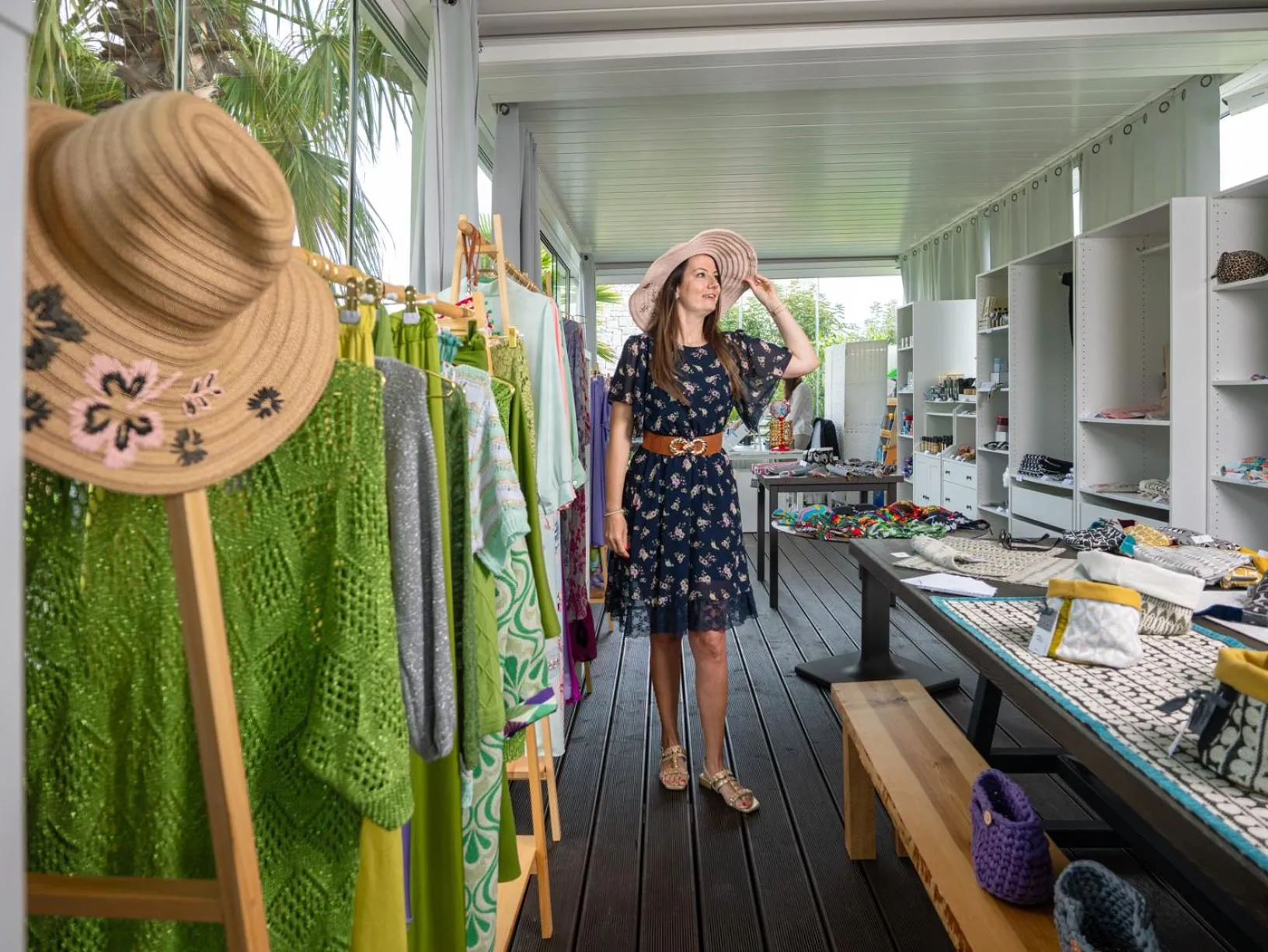 Une cliente choisit un vêtement dans une boutique en bord de mer.