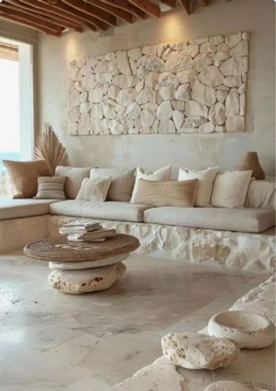 Espace de détente intérieur avec coussins et table basse en bois.