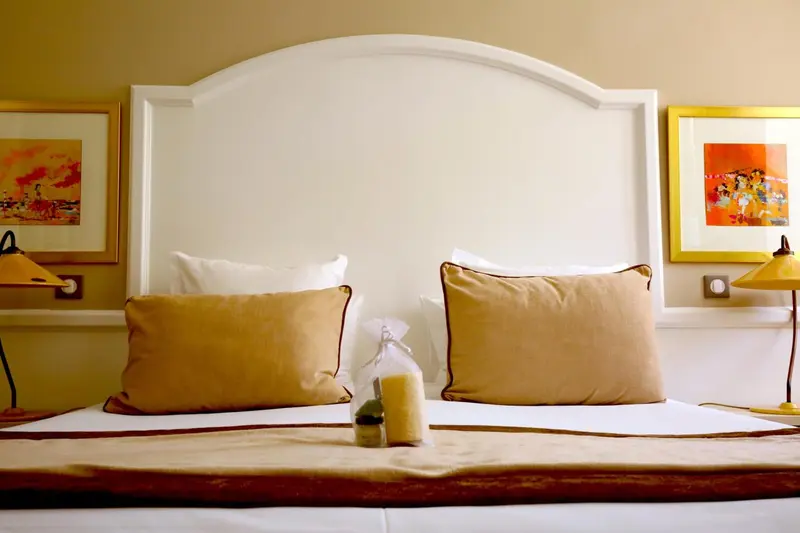 Un lit double avec des oreillers et des coussins dans une chambre.