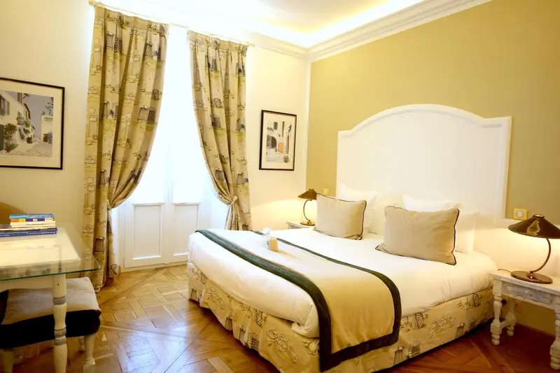 Une chambre lumineuse avec un grand lit et des rideaux décoratifs.