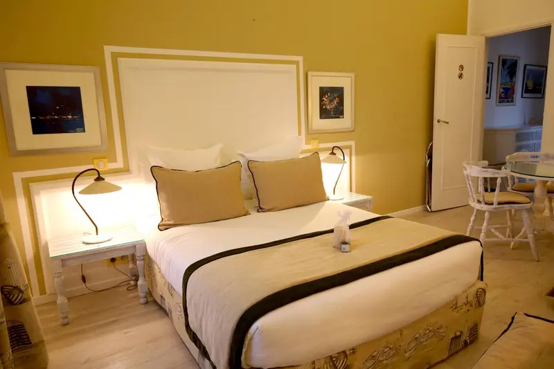 Une chambre lumineuse avec un grand lit et des tables de chevet.