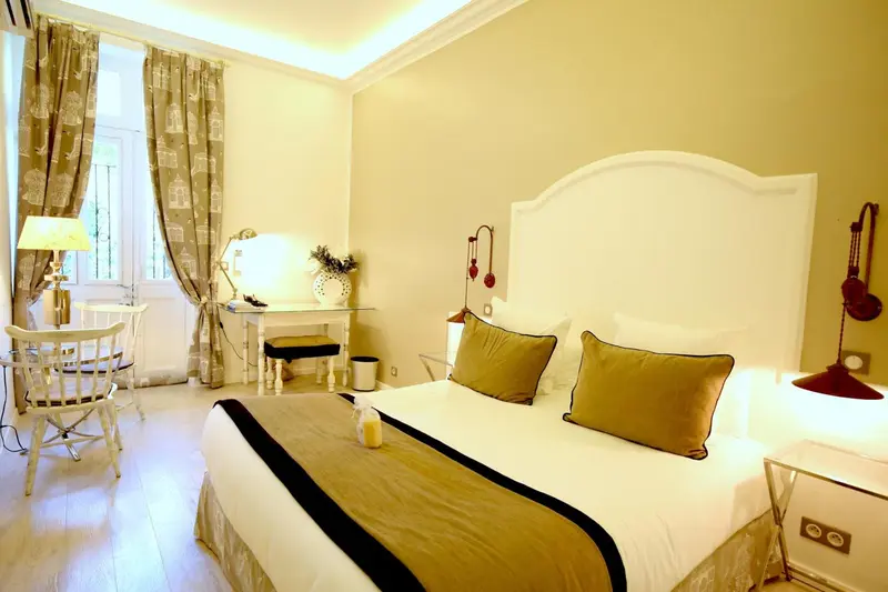 Une chambre lumineuse avec un grand lit et un coin bureau.