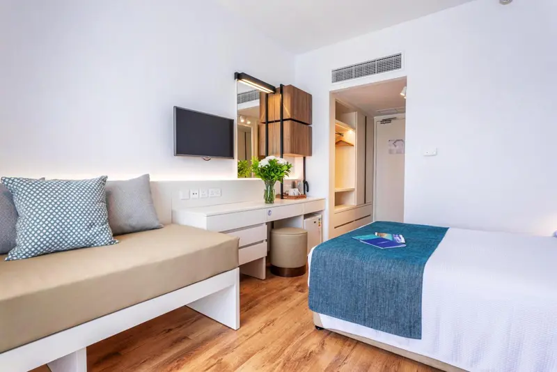 Une chambre lumineuse avec un canapé et un lit.
