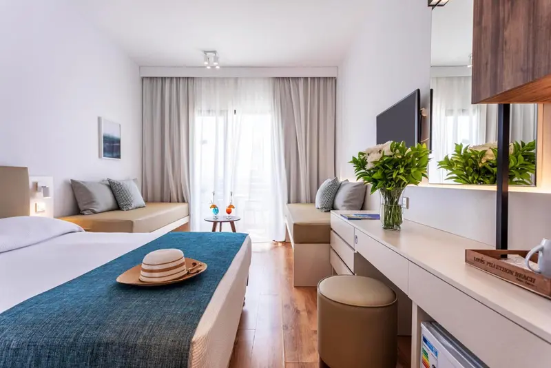 Une chambre lumineuse avec un lit et un coin salon.