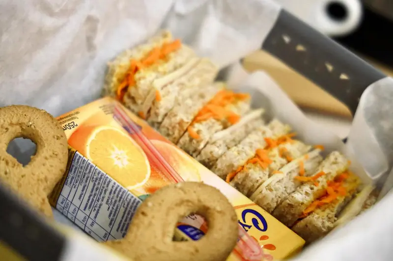 Assortiment de sandwichs et de jus d'orange dans une boite.