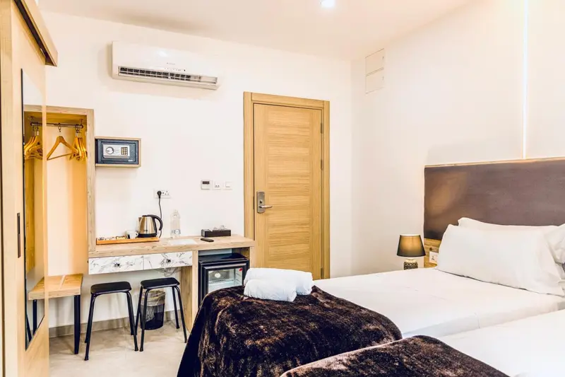 Une chambre lumineuse avec un lit double et un espace bureau.