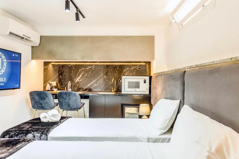 Une chambre avec un lit et une kitchenette.